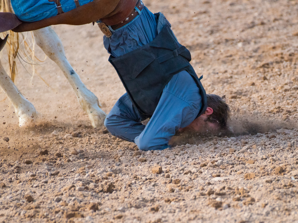 A cowboy falling off a horse, head first into some gravel. It's not a great look.